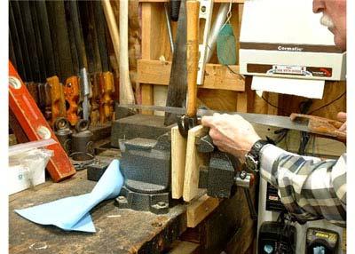 Place the hammer head in a vise between wooden jaws to protect the head.