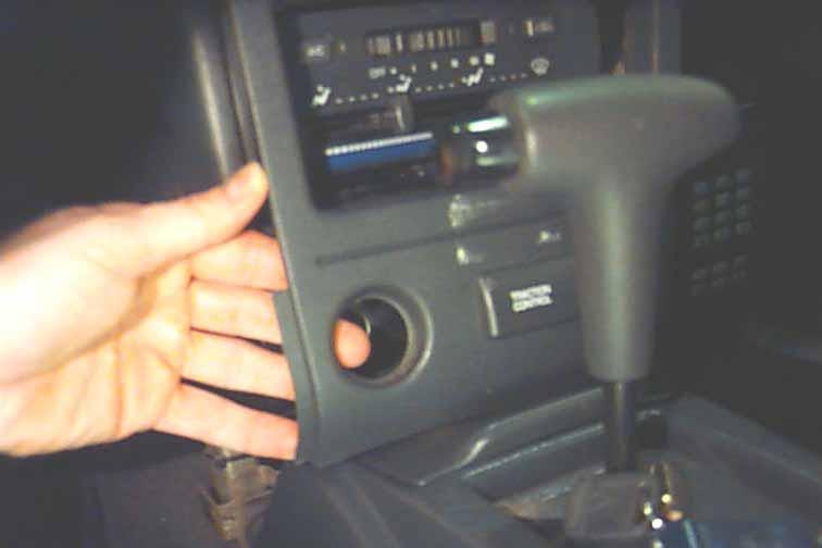 STEP 2: Reach your hand behind the bottom of the plastic dash panel (seen in the photo above behind the cigarette