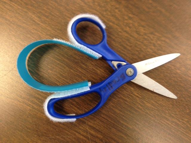 Adapted Scissors Materials 1 pair of regular scissors 1 strip of had plastic from folder Stickyback velcro Directions Place a strip of loop (soft) sided Velcro along the handles of the scissors Place