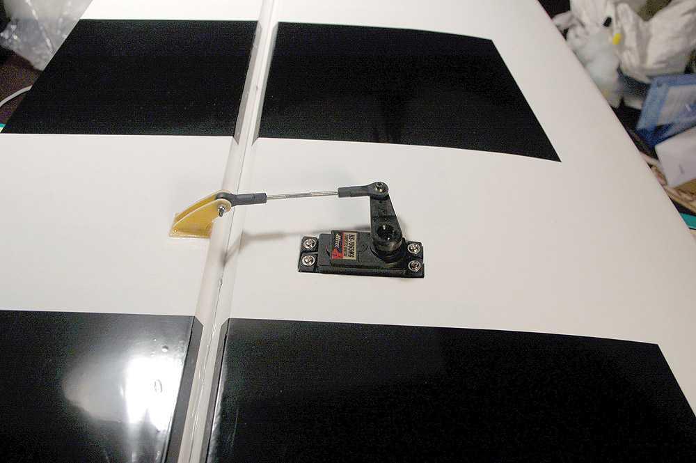 Use the string installed in the wing to pull the servo wire through the wing, then install the