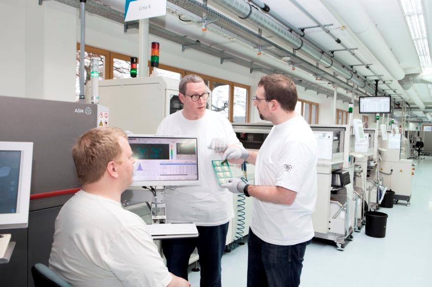 SMT production and process expert Benedikt Start (center) and his colleagues are excited about the SMT process, while the