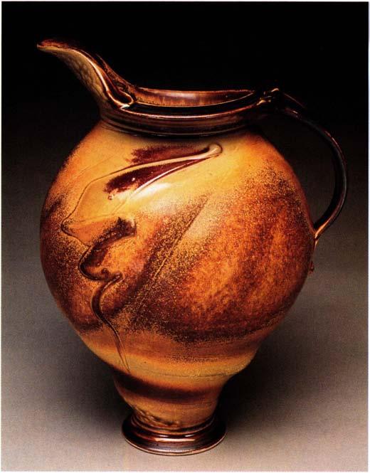 Melon Pitcher, 12 inches in height, thrown and altered stoneware, with trailed slip and sprayed Sohngen Stony Yellow. relative permanence of stoneware.