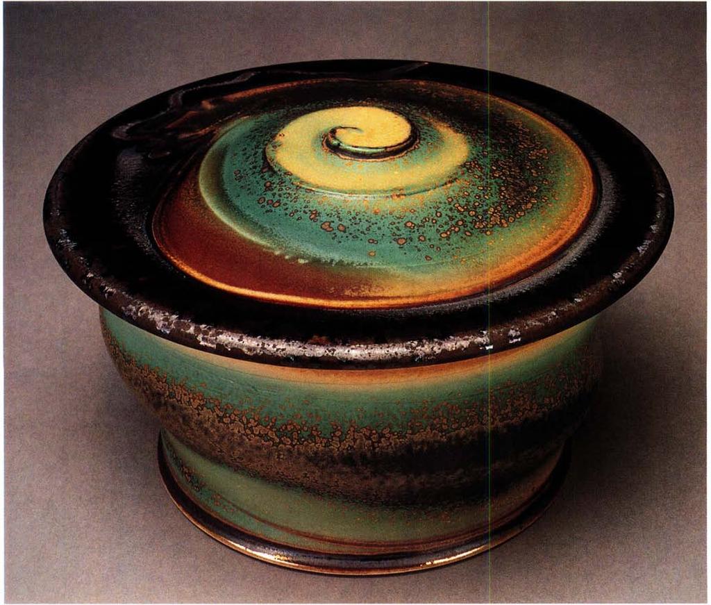 Covered jar, 4½ inches in height, thrown and altered stoneware, with contrasting glazes sprayed to emphasize spiral on lid, single fired, by Steven Hill, Kansas City, Missouri.