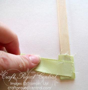 Apply more adhesive to both sides of the popsicle stick and wrap around the