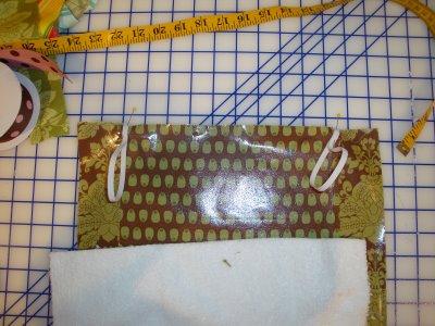 Attach 2 loops of ¼ elastic to top of changing pad.
