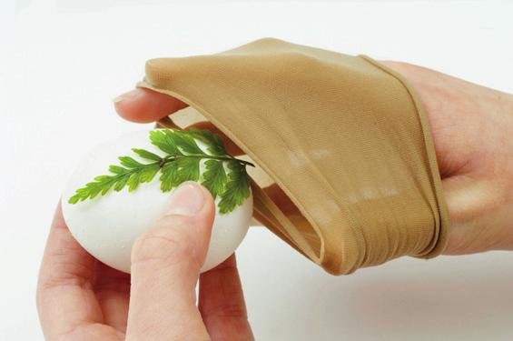 Lay a leaf on an egg, then cover it with a section of nylon stocking to hold it in place. 2.