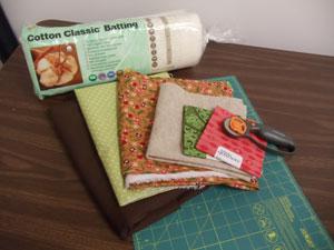 Supplies Needed: **1/3 yard solid colored cotton fabric (we used felt for embroidered center block) **1 1/2 yards solid colored quilter's cotton (for borders and back) **1/2 yard print quilter's