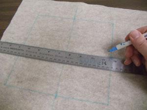 Prepare the fabric for the first embroidered center block. Using an air-erase pen or other marking tool, draw an 8 1/2" by 8 1/2" square on the solidcolored cotton fabric.