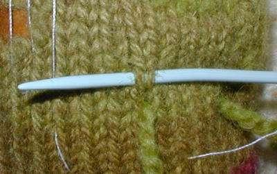 two rows if the yarn is thin), work duplicate stitch over the knit fabric, leaving a yarn tail of at least 6" / 15 cm that will be later darned in.