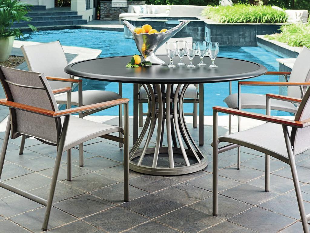 The 60-inch diameter round dining table features a graceful flared base in the platinum
