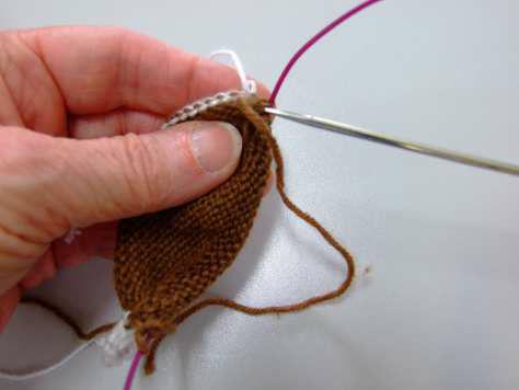 Grab the needle coming from the right end of your work. And insert it into the stitch held by the chain. 9.