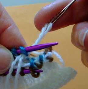 .stick your yarn needle knitwise, into the