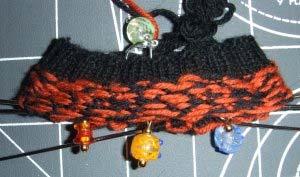 An example of stranding in the cuff along the inside of the fabric. Notice that the MC (orange) is twisted in every - stitches.