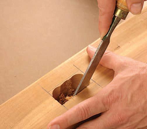 Figure : Square up the mortises with a sharp chisel and mallet. The sides of the drilled holes serve as a visual guide.