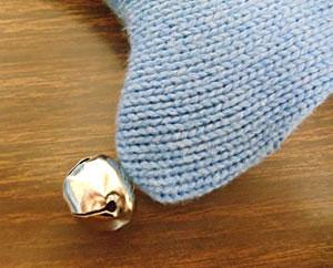 Hand-sew a bell to the tip of the stocking toe.