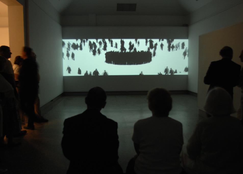 Museum visitors watch the following in one of the Musuem s galleries: Michal Rovner, More, 2003, projected digital video,