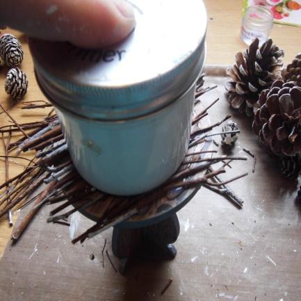 Use the base of the gesso pot to push the twigs onto the glue.