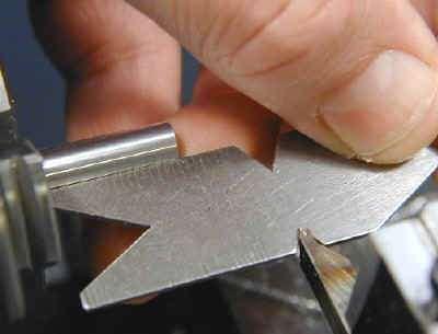 To align the tool bit to the work: 1. Ensure that the point of the tool bit is set at the center height of the lathe. 2. Place the center gage between the point of the tool bit and the work piece.
