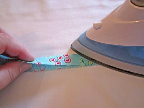 4. Unfold so the crease line is visible. 5. Fold in each long raw edge so they meet in the middle at the crease line.