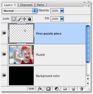 This cuts the piece out of the Puzzle layer and places it on its own layer above the Puzzle layer, which we can see in the Layers palette.