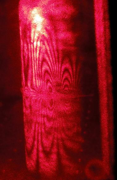 The interference fringes could then be analyzed using thin film interference theory to determine the amount the can was deformed by the rubber band.