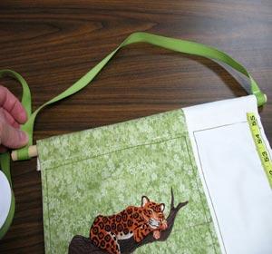 Remove the ribbon from the dowel and neatly stitch loop in place.