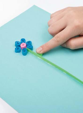 10 Add leaves. Dip one side of two green rolls in the glue. Put them on either side of the stem. Let the glue dry.