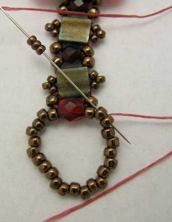 15 66. Pick up 3 copper 15/0 beads and bring your needle through the 2nd and 3rd bead in the ring.