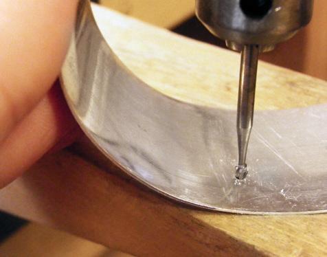 Using the flat side of a riveting hammer, lightly strike the ball of the head pin to slightly flatten it [1]. Drill the wire-rivet holes.
