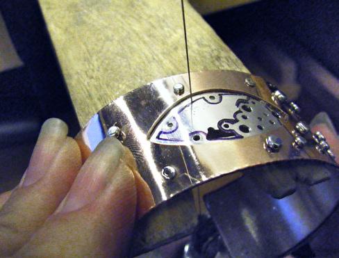 Using a half-round file, file the inside ends of the wire and tube rivets flush with the liner. Sand the entire inner surface of the cuff, using 400- and then 600-grit sandpaper.