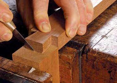 Mortise for the runners and kickers. The top rail is dovetailed into the tops of the leg posts. The author rabbets the tail to enhance accuracy when transferring the layout.