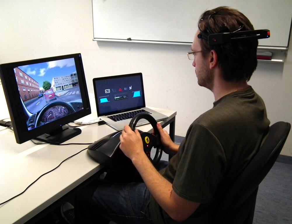 114 Controlling In-Vehicle Systems with a Commercial EEG Headset Figure 1 Image of a participant while interacting with the driving simulator and the EEGcontrolled dashboard.