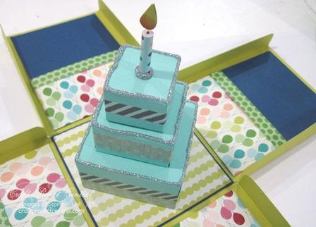 Step 17 Apply Silver Sparkle Dazzling Details onto the corners of the cake layers and around the base of the candle.