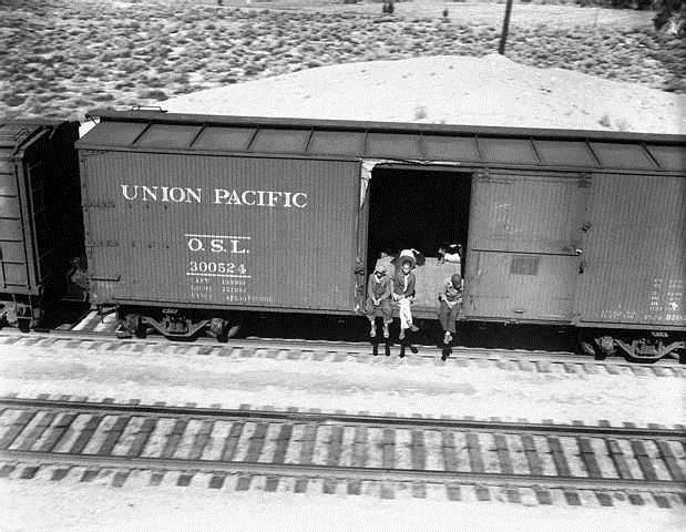Hobos Riding Freight Car to California Several hobos ride a freight car hanging over the side