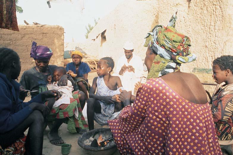She was the president of the potters and my mother in the village. Alima the first wife of one of Boh s sons is giving her infant son Bagardi some medicine while the rest of the family watches.