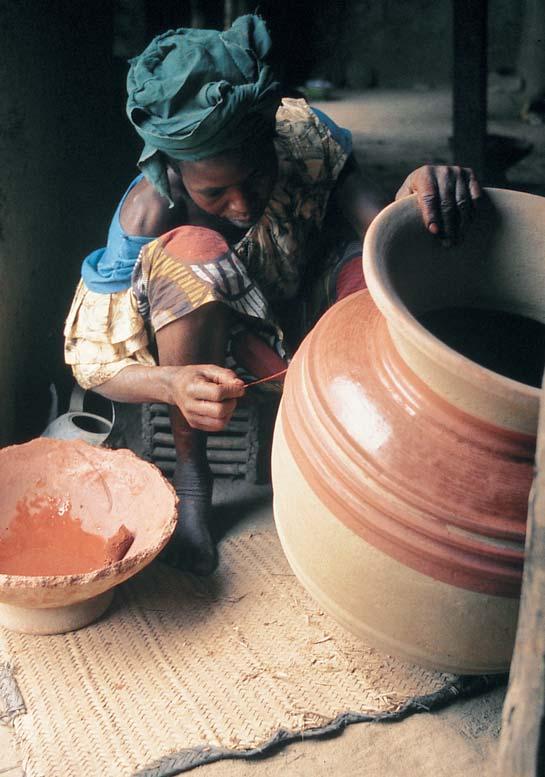 6 GLAZING A red stone slip, purchased in the market, is applied to the formed and dried pot before firing. The color is applied to the large areas with a sponge that can be seen in the bowl of slip.