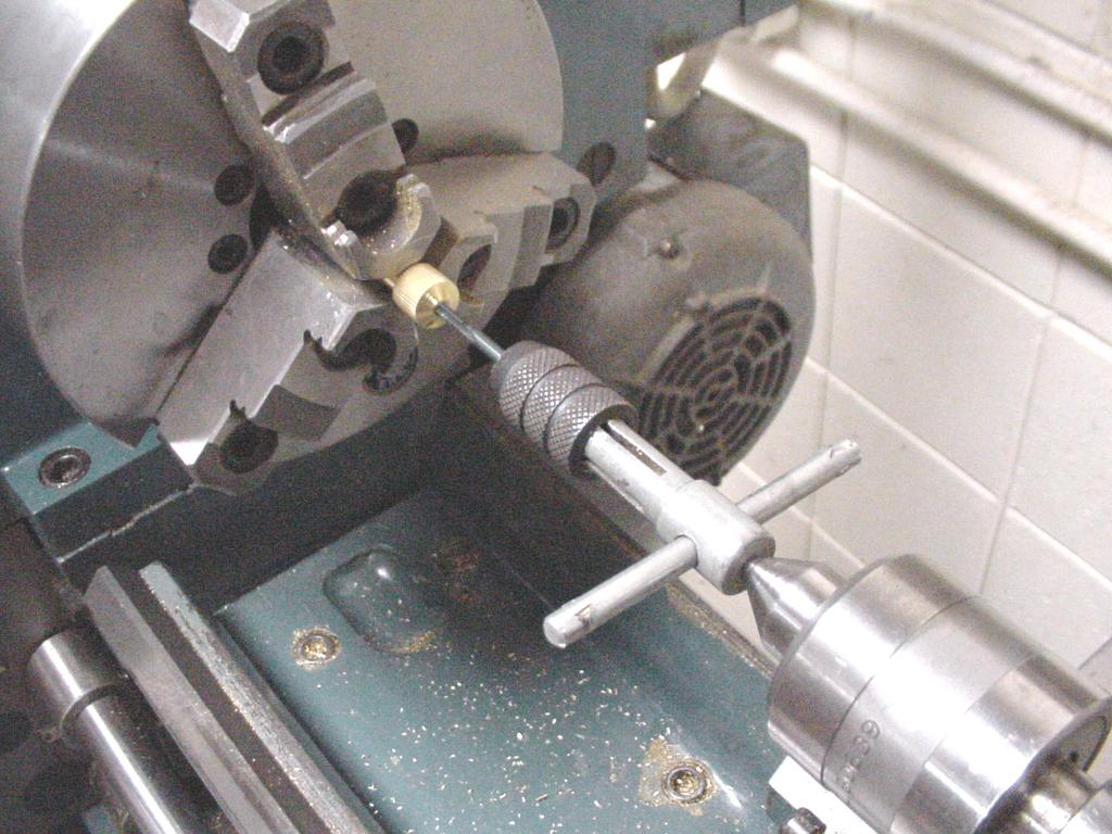 To ensure that internal threads are cut square, a live center can be placed in the tailstock to support the tap handle.
