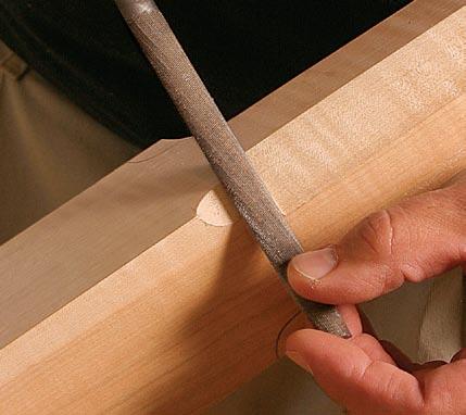 Next, find the center of the post, and use a long straightedge to transfer that line up into the tapered section. Now mark out the locations of the top and bottom of the headboard mortise.