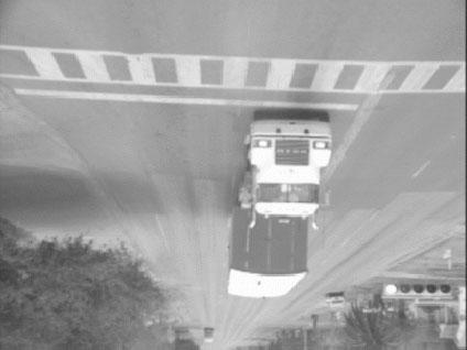 Adjacent-lane occlusion from a left-side camera can be caused by vehicles approaching or departing the intersection.