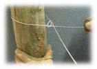 Take the loose tail of wire that is sticking up along the post and bend this wire sharply down