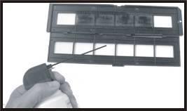 recommend that you use compressed air (not included) to remove any dust on the negatives. Insert the negative holder into the slot on the right side of the scanner as shown below.