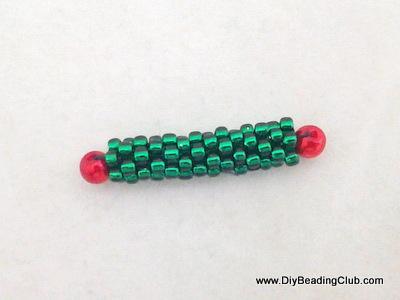 Step 16: When you reach the end of the tube, in this case the right end take a 4mm red pearl and weave back through several