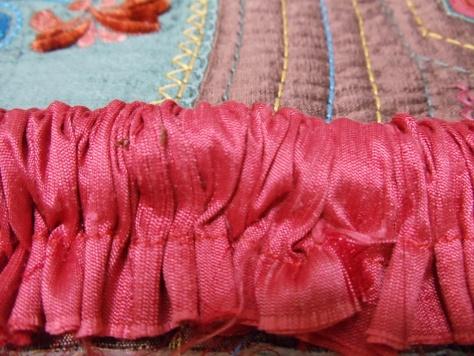 Align the raw edges of the cording fabric with the raw edges of the pillow. Pin them together, starting in the middle of the bottom edge of the pillow.