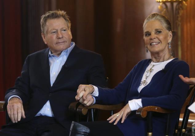 Actors Ryan O'Neal, left, and Ali MacGraw hold hands as they are introduced for a talk with students on the campus of Harvard University in Cambridge, Mass., Monday Feb.
