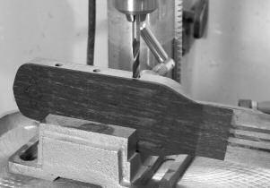 The headstock edge can be held in a drill press vice at 90 to the 1 /4 in 6.35mm drill bit. I use tuners with a shaft that are 1 /4in 6.35mm in diameter and omit the bushings.