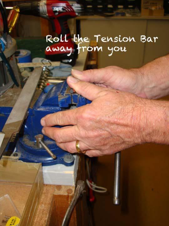 25. Mount tension bar behind the tone block so that it rests on the small leather pieces on the two arms. Then pull the spring loop up and attach it to the middle spring claw.