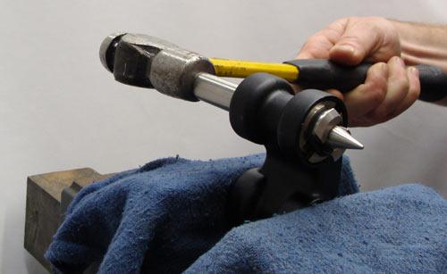 d) Use a mallet or hammer to tap bearings out while holding the link to the table.