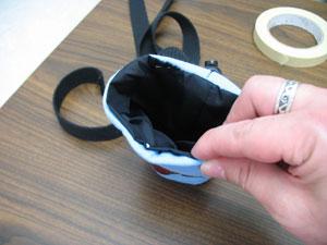 Turn the inner lining right side out, remove the tape from the straps, and insert the inner lining inside the outer shell.