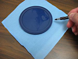 To prepare the bottom portion of the carrier, lay the plastic lid over the canvas, trace and cut out the shape.