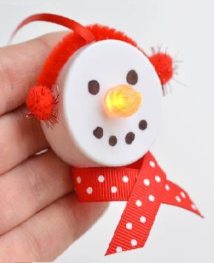 Tea Light Snowman Ornaments Battery operated tea lights 1 Black and 1 Orange Sharpie Red Ribbon (like this and this) Red Pipe Cleaners Red Pom Poms Glue Gun 1.